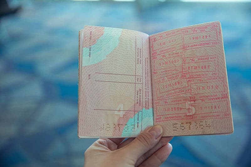 Close-up view of an open passport displaying various travel stamps